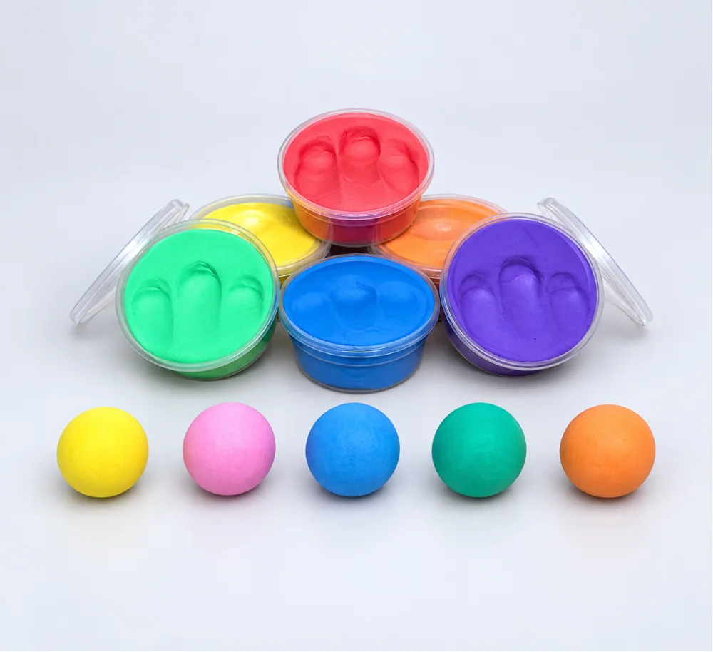 Open tubs of colourful foam clay with clay balls arranged in front.