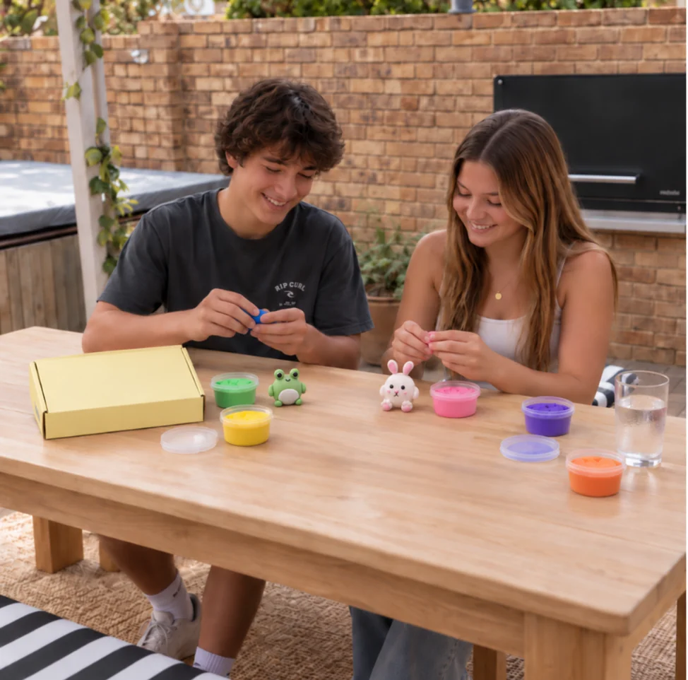 Two people enjoying a clay kit together at an outdoor table.