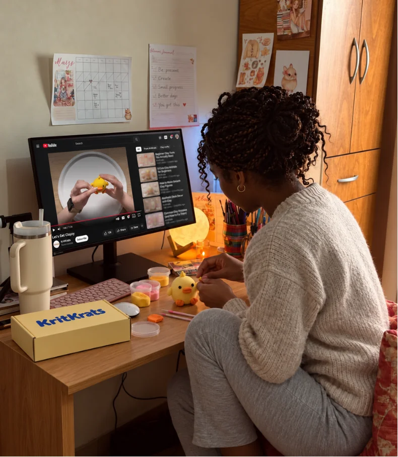A person enjoying quiet time making a clay chick while following a video tutorial.